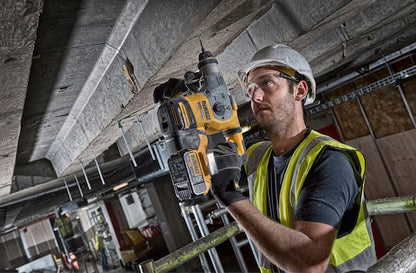Ein Mann bohrt ein Loch in die Decke senkrecht nach oben mit einem Dewalt DCH283NT 18 Volt SDS-plus Akku-Kombihammer 26mm (bürstenlos